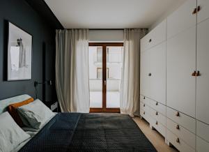 a bedroom with a bed and a large window at Apartament Szyperska 23 Stare Miasto in Poznań