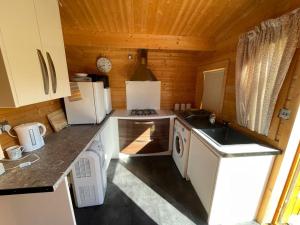 uma cozinha com electrodomésticos brancos numa cabina de madeira em Secret Hythe, Sea views Town location 2km Eurotunnel em Hythe