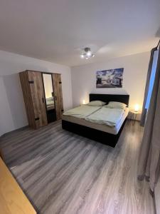 1 dormitorio con 1 cama y suelo de madera en Schöne helle Ferienwohnung 64qm mit Kingsize Bett, Smart-TV, Wlan und sehr ruhige Lage, en Erfurt