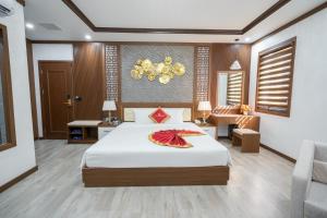 une chambre d'hôtel avec un lit et une chaise dans l'établissement Sunland Halong Hotel and Restaurant, à Hạ Long