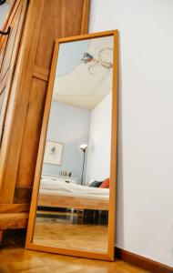 un espejo sentado en el suelo junto a una cama en Casa Celio Ambrì, en Quinto