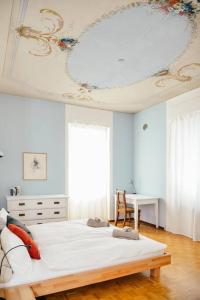 a bedroom with a large white bed with a ceiling at Casa Celio Ambrì in Quinto