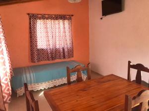 comedor con mesa y ventana en El Jacaranda 2 - Complejo en Agua de Oro