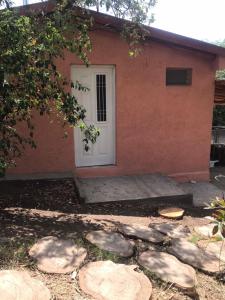 uma casa com uma porta branca e pedras na frente dela em El Jacaranda 2 - Complejo em Agua de Oro