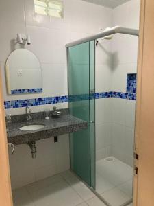 a bathroom with a glass shower and a sink at Casa de praia no Ariramba, Mosqueiro, Belém/PA. in Belém