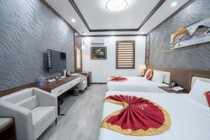 pokój hotelowy z dwoma łóżkami i telewizorem w obiekcie Sunland Halong Hotel and Restaurant w Ha Long