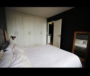 a bedroom with a large white bed and a mirror at Fountain Suites Aparthotel - PRIVATE in Cape Town +4 photos