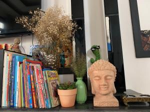 uno scaffale con un busto di testa e libri di Sophia Homestay Hoi An a Hoi An
