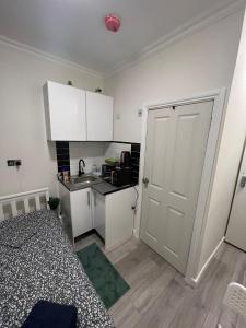 a small room with a bed and a kitchen at Lovely apartment close to Acton central station in London