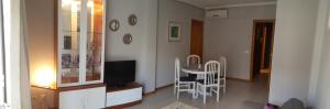 sala de estar con mesa, sillas y TV en Apartamento acogedor en el centro de Valdepeñas, en Valdepeñas