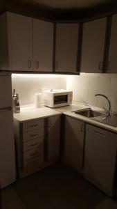 una pequeña cocina con microondas y fregadero en Apartamento acogedor en el centro de Valdepeñas, en Valdepeñas
