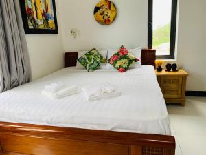 een slaapkamer met een bed met witte lakens en kussens bij Sophia Homestay Hoi An in Hội An