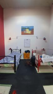 a room with three beds in a room with a wall at Posada Doña Mari AgricolaOriental in Mexico City