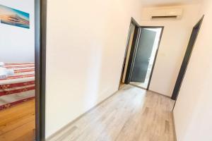 una stanza vuota con una porta e un pavimento in legno di Apartmani Vlahušić a Putniković