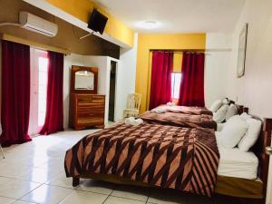a bedroom with a large bed and red curtains at Hotel Art Deco Beach in La Ceiba +95 photos