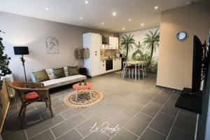 ein Wohnzimmer mit einem Sofa und einem Tisch in der Unterkunft LE JUNGLE 5 étoiles / Netflix et services in Saint-Jean-Bonnefonds