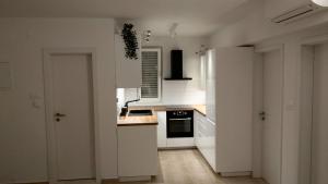 uma cozinha com armários brancos e um forno com placa de fogão em Mira em Splitska