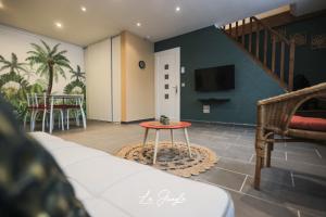 LE JUNGLE 5 étoiles / Netflix et services في Saint-Jean-Bonnefonds: غرفة معيشة مع أريكة وطاولة