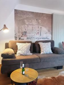 ein Wohnzimmer mit einem braunen Sofa und einem Tisch in der Unterkunft stilvolle Wohnung direkt in der City in Würzburg