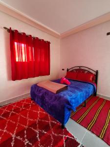 a bedroom with a bed and a red window at auberge restaurant tizgui in Tinerhir