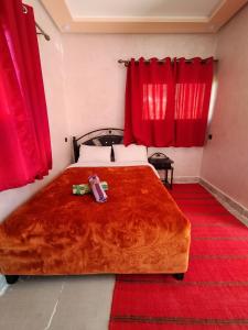 a bedroom with a large bed with red curtains at auberge restaurant tizgui in Tinerhir