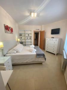 1 dormitorio con 1 cama, vestidor y TV en Apartamento CyM, en Ronda