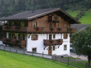a large wooden house with flower boxes on the windows at Schiederhof in Mittersill