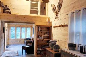 a living room of a log cabin with a refrigerator at Cozy Accessible Waterfront Cottage on Healey Lake in Bracebridge
