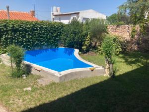 a small blue swimming pool in a yard at Ashram Asociación Argentina de Yoga in Mina Clavero