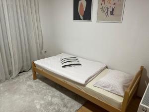Cama pequeña en habitación con paredes blancas en Apartman House Jasmina en Bihać