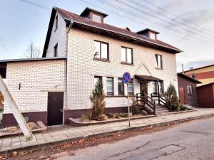 une maison en briques blanches sur le côté d'une rue dans l'établissement KALIDA B&B Rooms for rent, à Raseiniai