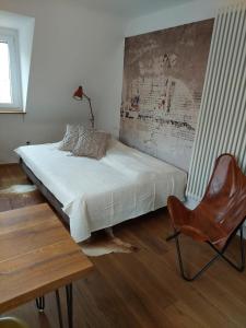 a bedroom with a bed and a chair and a table at stilvolle Wohnung direkt in der City in Würzburg