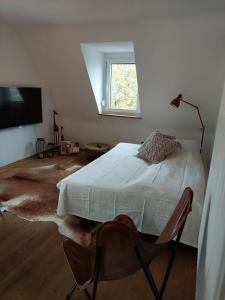 a white bedroom with a bed and a window at stilvolle Wohnung direkt in der City in Würzburg