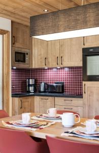 A kitchen or kitchenette at Chalet Hôtelier LES EQUINOXES - VAL D'ISERE