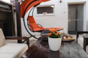 a white vase with flowers on a wooden table at Ande House in Orşova