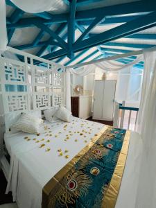 a bedroom with a white bed with a blue ceiling at Villa Paradis in Le François