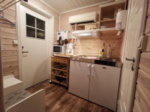 małą kuchnię ze zlewem i kuchenką mikrofalową w obiekcie Utsikten w mieście Gjesvær
