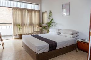 sypialnia z łóżkiem z białą pościelą i poduszkami w obiekcie Greenscape Colombo w Kolombo