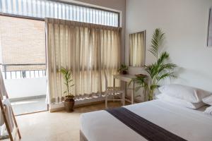 a bedroom with a bed and a large window at Greenscape Colombo in Colombo