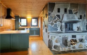 a kitchen with a stone stove on the wall at Amazing Home In Sjusjøen With Sauna in Sjusjøen