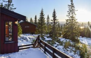 a cabin in the snow with a fence at Amazing Home In Sjusjøen With Sauna in Sjusjøen