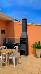 Un patio con chimenea y una mesa y sillas. en Vilamaruá Chalé próximo da praia do Perequê, en Ilhabela 8 fotos más