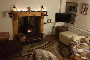 un salon avec une cheminée et un canapé dans l'établissement Isallt Cosy Cottage. Dogs Welcome. Superking & Double Bed. Log Burner. Peaceful Village Location, à Llanbrynmair 74 autres photos