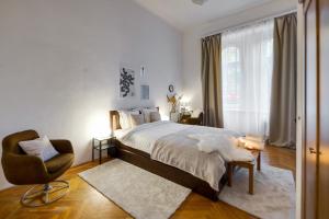 a bedroom with a bed and a chair and a window at Felsőerdősor Residence in Budapest