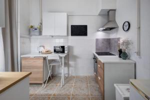 una pequeña cocina blanca con mesa y microondas en Felsőerdősor Residence en Budapest