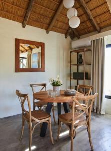 uma sala de jantar com uma mesa de madeira e cadeiras em Posada Tamarindo em José Ignacio