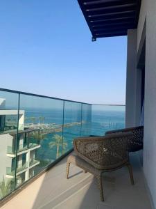 a bench on a balcony with a view of the ocean at Ocean Mountain View Apartment at The Address Fujairah in Fujairah