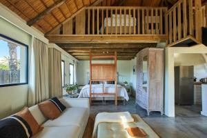 a living room with a couch and a bed at Posada Tamarindo in José Ignacio