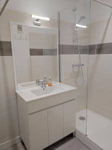 a white bathroom with a sink and a shower at Chamrousse 1750 - Le Taillefer - Appartement classé 3 étoiles in Chamrousse