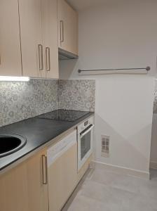 a kitchen with white cabinets and a sink at Chamrousse 1750 - Le Taillefer - Appartement classé 3 étoiles in Chamrousse